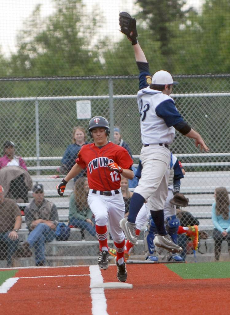 Kenai&rsquo;s Porter Fannon runs to first base as Eagle River first baseman Logan Smith leaps unsuccessfully for the throw during the second game of an Alaska American Legion Baseball doubleheader between Kenai Post 20 and Eagle River on Saturday, July 1, 2017 at the Loretta French Sports Complex in Chugiak. Eagle River won 11-6. (Photo by Matt Tunseth/Chugiak-Eagle River Star)