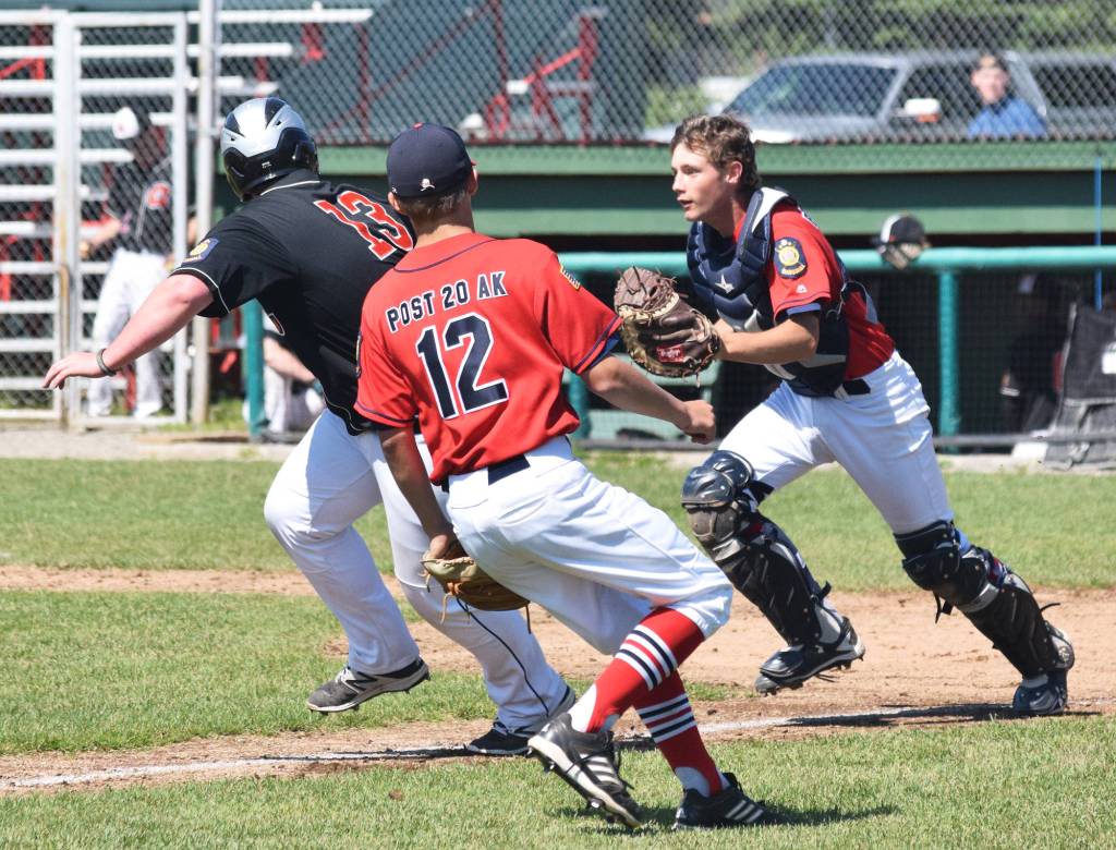 Post 20 Twins catcher Seth Adkins catches West baserunner Thomas Zettler (13) between third base and home plate Thursday at the Bill Miller Wood Bat Tournament at Coral Seymour Memorial Ballpark in Kenai. (Photo by Joey Klecka/Peninsula Clarion)