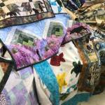 A selection of Dana Woodard&rsquo;s quilted artwork is on display at her family&rsquo;s store, Kenai Fabric Center, in Kenai. Gwen Woodard, Dana&rsquo;s mother, says that a major part of their sales are based on Dana&rsquo;s designs and patterns. (Photo by Kat Sorensen/Peninsula Clarion)