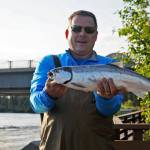 Tom Lyman of Michigan holds up a sockeye salmon he caught in the Kenai River on Wednesday, July 12, 2017 in Soldotna, Alaska. Lyman, who is visiting Alaska with his son, said he hadn&rsquo;t been casting for long when he hooked into the fish. (Photo by Elizabeth Earl/Peninsula Clarion)