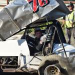 Logan McDonald steers his father John&rsquo;s crumpled No. 78 Sprint car back to the pits after John endured a rollover crash during the running of the Alaska Dirt Track Shootout held Saturday at Twin City Raceway in Kenai. (Photo by Joey Klecka/Peninsula Clarion)