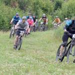 Mike Crawford leads the pack off the start of Soldotna Cycle Series Race 6 on Thursday, Aug. 3, 2017, at Tsalteshi Trails. (Photo by Jeff Helminiak/Peninsula Clarion)