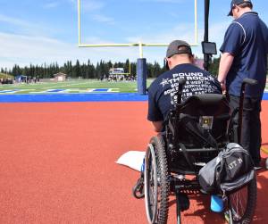 Matthew Martinelli, with the Soldotna Stars motto &ldquo;Pound the Rock&rdquo; emblazoned on his back, helps film a varsity scrimmage between Soldotna and Chugiak High School Saturday at Justin Maile Field. (Photo by Joey Klecka/Peninsula Clarion)