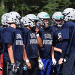 A group of Soldotna players discuss play-calling in an Aug. 5 scrimmage against Chugiak at Justin Maile Field in Soldotna. (Photo by Joey Klecka/Peninsula Clarion)