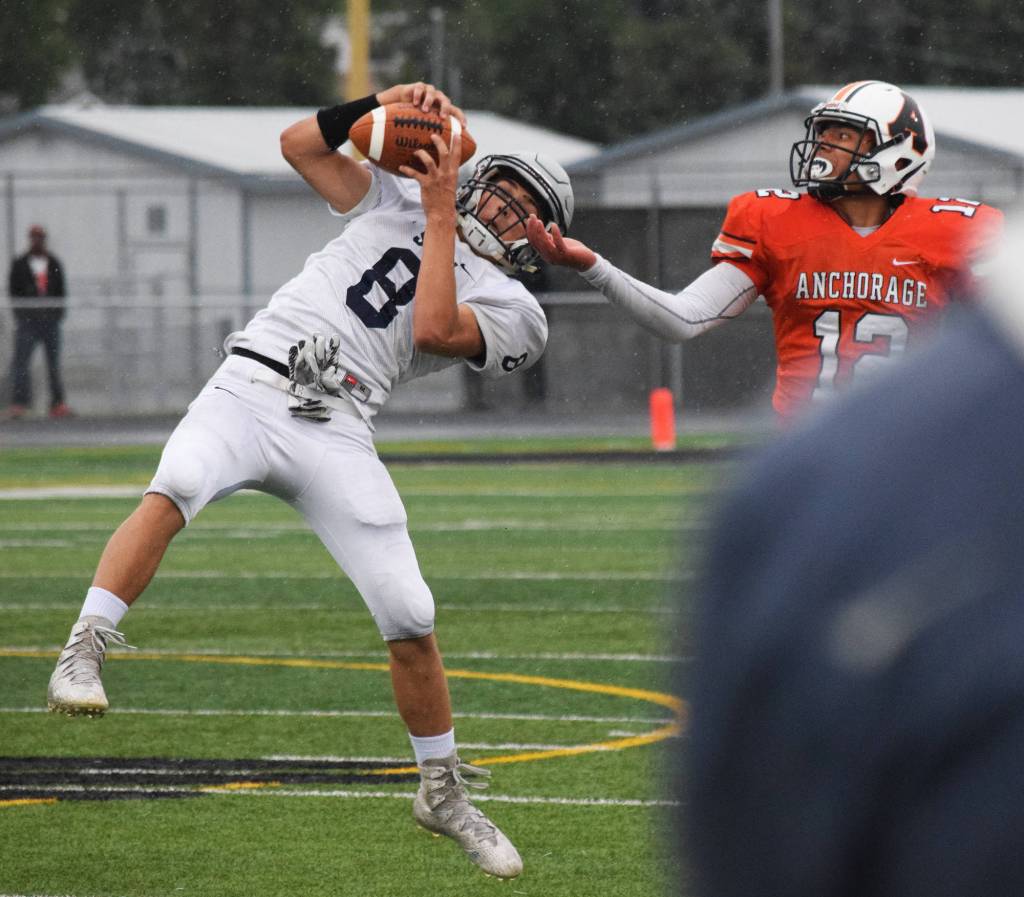 Soldotna&rsquo;s Cy Updike hauls in an interception in front of West receiver A.J. Su&rsquo;esu&rsquo;e Friday at West Anchorage High School. (Photo by Joey Klecka/Peninsula Clarion)