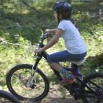 Lexi Larson eases her way down a banked turn on the Mosquito singletrack trail on July 2, 2014 at Tsaleteshi Trails in Soldotna. Work is under way to improve the original singletrack and add more to the trail system. (Clarion file photo)