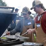 Joey Allegrini, left, and Dalton Dosko of the Kenai River Brown Bears ice hockey team help serve food during Industry Appreciation Day on Saturday, Aug. 26 in Kenai. (Photo by Kat Sorensen/Peninsula Clarion)