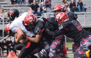 Juneau running back Liam Van Sickle gets tackled by several Kenai defenders, including James Siamani (25) and John Grossl (65) Saturday afternoon at Ed Hollier Field in Kenai. (Photo by Joey Klecka/Peninsula Clarion)