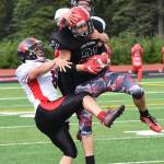 Kenai Central senior Zack Tuttle hauls in a long pass from quarterback Connor Felchle as Juneau defensive backs Donavin McCurley (right) and Liam Van Sickle hang on, Saturday afternoon at Ed Hollier Field in Kenai. (Photo by Joey Klecka/Peninsula Clarion)