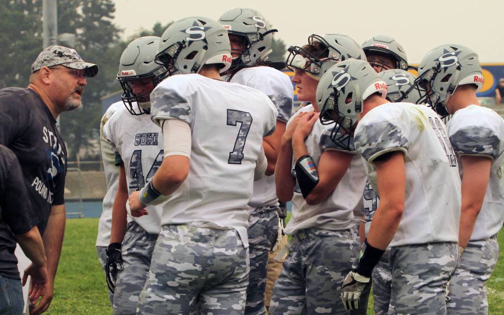 Soldotna head coach Galen Brantley Jr. discusses strategy with his team Friday, Sept. 1, 2017, at Del Norte County High School in Crescent City, California. The Stars defeated Crater High School of Oregon 20-7 in the game. (Photo by Michael Zogg/Del Norte Triplicate)