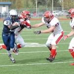 Eagle River&rsquo;s Kam Williams is corralled by Kenai&rsquo;s Jakob O&rsquo;Brien (7), Seth Kruse (63) and Titus Riddall (22) during Kenai&rsquo;s 42-28 Northern Lights Conference football win over the Wolves on Saturday, Sept. 2, 2017 at Eagle River High School. (Star photo by Matt Tunseth)