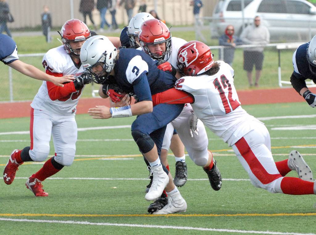 Eagle River&rsquo;s Ryan Adkins is tackled by several Kenai players during the Kardinals&rsquo; 42-28 Northern Lights Conference football win over the Wolves on Saturday, Sept. 2, 2017 at Eagle River High School. (Star photo by Matt Tunseth)