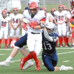 Kenai&rsquo;s Titus Riddall is tackled by Eagle River&rsquo;s JT Adams, right, and Bryson Rollman during the Kardinals&rsquo; 42-28 Northern Lights Conference football win over the Wolves on Saturday, Sept. 2, 2017 at Eagle River High School. (Star photo by Matt Tunseth)