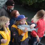 A young angler kisses her first silver salmon for luck.
