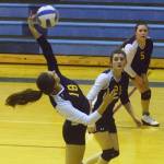 Homer sophomore Marina Carroll (21) and junior Ksenia Kuzmin (5) look on as senior Mariners teammate Raisa Basargin delivers a shot against Soldotna Tuesday night at Soldotna High School. (Photo by Joey Klecka/Peninsula Clarion)