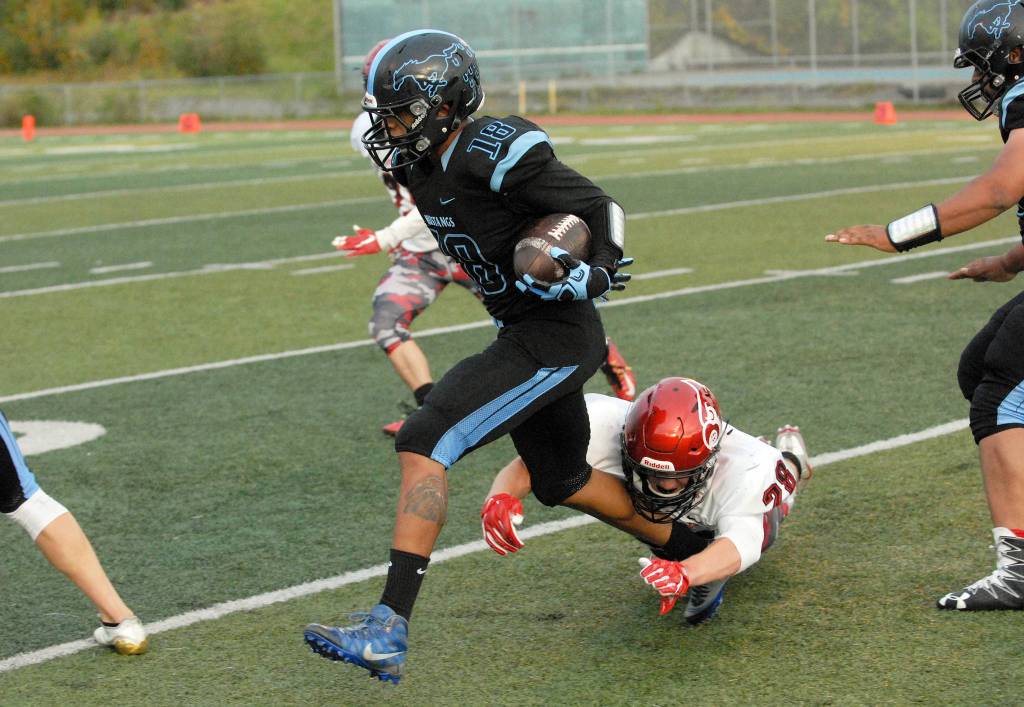 Chugiak&rsquo;s Ramal Maad tries to break free of Kenai Central&rsquo;s Rykker Riddall during Chugiak&rsquo;s 48-0 nonconference high school football win over Kenai on Friday, Sept. 15, 2017 at Tom Huffer Sr. Stadium in Chugiak. (Star photo by Matt Tunseth)