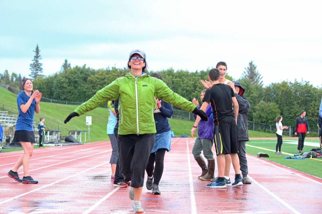 Saundra Hudson crosses the finish line of her first mile run in six months during the Mariner Mile event Thursday, Sept. 14, 2017 at the high school track in Homer, Alaska. Hudson, an active member of and advocator for the Homer running community and teacher at Homer High School, experienced a head injury when she slipped on the ice running this past March, and Thursday&rsquo;s fundraising event for the Kachemak Bay Running Club was her first return to running since then. (Photo by Megan Pacer/Homer News)