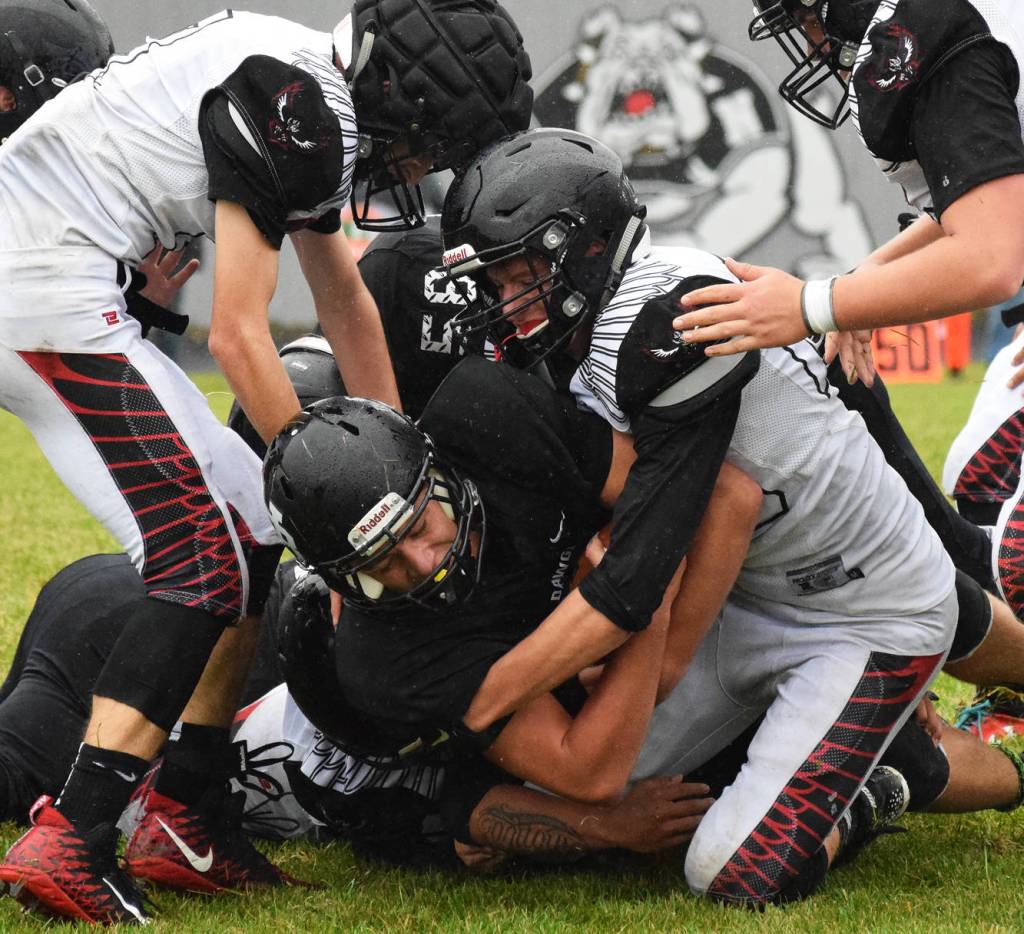 Nikiski senior Ian Johnson (middle) is tackled by a host of Eielson players Friday evening at Nikiski High School. (Photo by Joey Klecka/Peninsula Clarion)