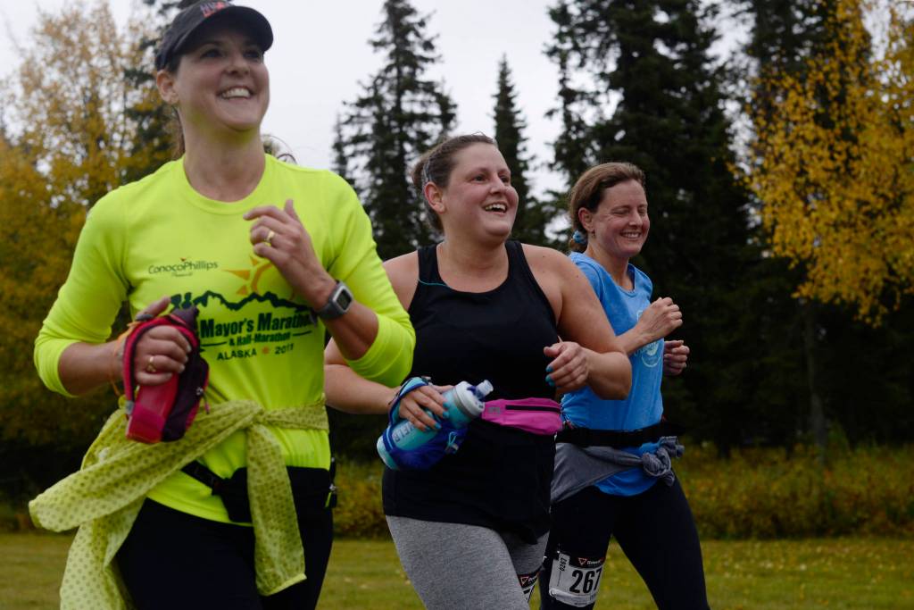 Runners Kimberly Buskirk (left), Kate Swaby, and Candace Cartwright run in the Kenai River half-marathon on Sunday, Sept. 24, 2017 in Kenai, Alaska.