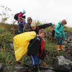 Fourth grade students from McNeil Canyon Elementary School descend to the shoreline from Spit Road to clear away trash Friday, Sept. 22, 2017 near Mariner Park in Homer, Alaska. Each year, citizen groups and students from area schools can adopt a section of Kachemak Bay shoreline where they clean debris and observe changes for the Kachemak Bay CoastWalk, hosted by the Center for Alaskan Coastal Studies. (Photo by Megan Pacer/Homer News)