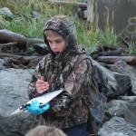 Tanner Johnson, a fourth grader at McNeil Canyon Elementary School, marks down his group&rsquo;s findings on a clipboard while he and classmates clean the shoreline on Friday, Sept. 22 near Mariner Park in Homer. Many school classes and citizen groups sign up each year to scour a section of coast during the annual Kachemak Bay CoastWalk, hosted by the Center for Alaskan Coastal Studies. (Photo by Megan Pacer/Homer News)