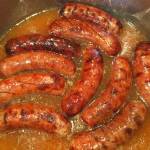 This Sept. 17 photo shows bratwurst sausages simmered in beer in Houston. This dish is from a recipe by Elizabeth Karmel. (Elizabeth Karmel via AP)