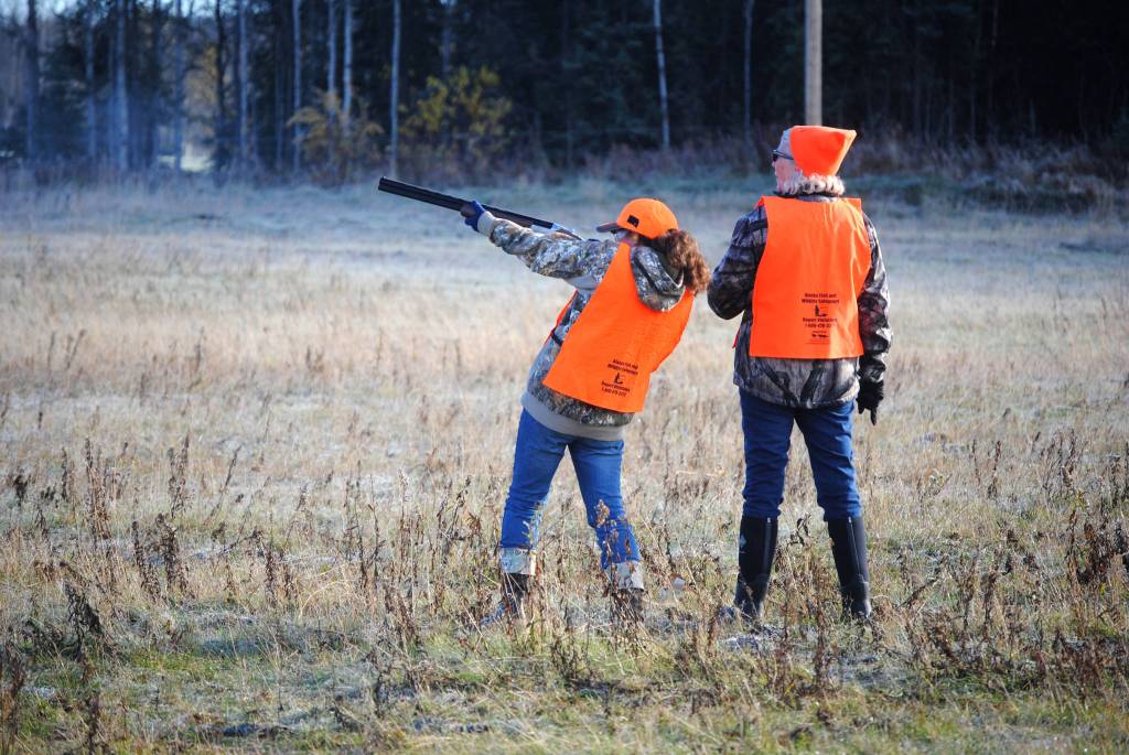 Top: Behka Baeten takes a shot at a chukar with guidance from Billie Hardy during Safari Club International&rsquo;s bird hunt on Saturday in Funny River.  Center: Monica Reid holds back her dog Bella during a bird hunt in Funny River on Saturday. Bella recently returned from learning the basics of bird hunting in Minnesota and Reid attended Saturday&rsquo;s hunting event in hopes of learning to practicing both her and Bella&rsquo;s hunting skills. Bottom: Safari Club International volunteers work closely with participants throughout the day in Funny River on Saturday, Oct. 7 to ensure safety and an understanding of the basics of shooting and hunting.