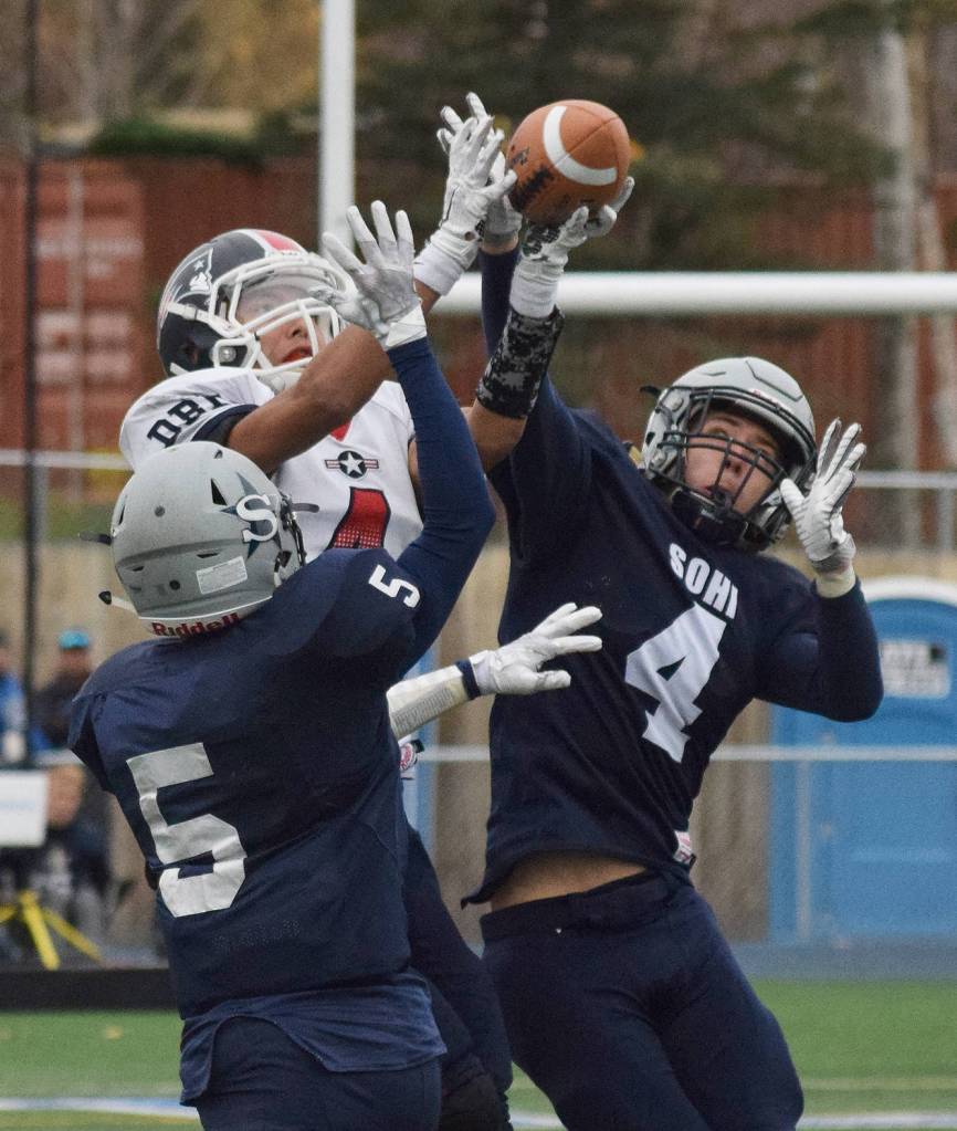 Soldotna defenders Luke Trammell (5) and Jersey Truesdell team up to cover North Pole receiver Jamie Johnson (middle) Saturday at the ASAA First National Bank state football semifinals at Palmer High School. (Photo by Joey Klecka/Peninsula Clarion)