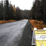 A sign advertising a public meeting about the plan for a multipurpose trail alongside Ski Hill Road stands alongside the road itself Thursday, Oct. 12, 2017 in Soldotna, Alaska. Many people choose to walk the road, which winds into the woods near the Kenai National Wildlife Refuge Visitor&rsquo;s Center, for exercise, but there have been concerns in the past about conflict between cars and pedestrians on the road. The refuge and the Federal Highway Administration are in the process of planning a pedestrian pathway somewhere along the road to help divert foot traffic away from the road itself. (Photo by Elizabeth Earl/Peninsula Clarion)