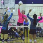 Soldotna junior Aliann Schmidt delivers a spike between Nikiski seniors Jamie Yerkes (9) and Rylee Jackson (10) Tuesday evening at Soldotna High School. (Photo by Joey Klecka/Peninsula Clarion)