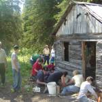 Kids from the Kenaitze Indian Tribe Susten Archaeology Camp excavate around a historical cabin in preparation for it be moved by Gary Titus from the Kenai National Wildlife Refuge. (Photo provided)