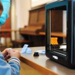 Isaac Perry, 5, checks out a cube produced by the Soldotna Public Library&rsquo;s new 3D printer during a demonstration at the library Thursday, Oct. 19, 2017 in Soldotna, Alaska. The library acquired the machine, which can print three-dimensional objects out of plastic based on a submitted pattern, in July and is now making it available for public use. It&rsquo;s currently free, supported by funds from the Soldotna Library Friends, with a suggested donation of $3 per print. Eventually, if demand outpaces supply, the library expects to have to establish a fee, according to the 3D printer policy. (Photo by Elizabeth Earl/Peninsula Clarion)