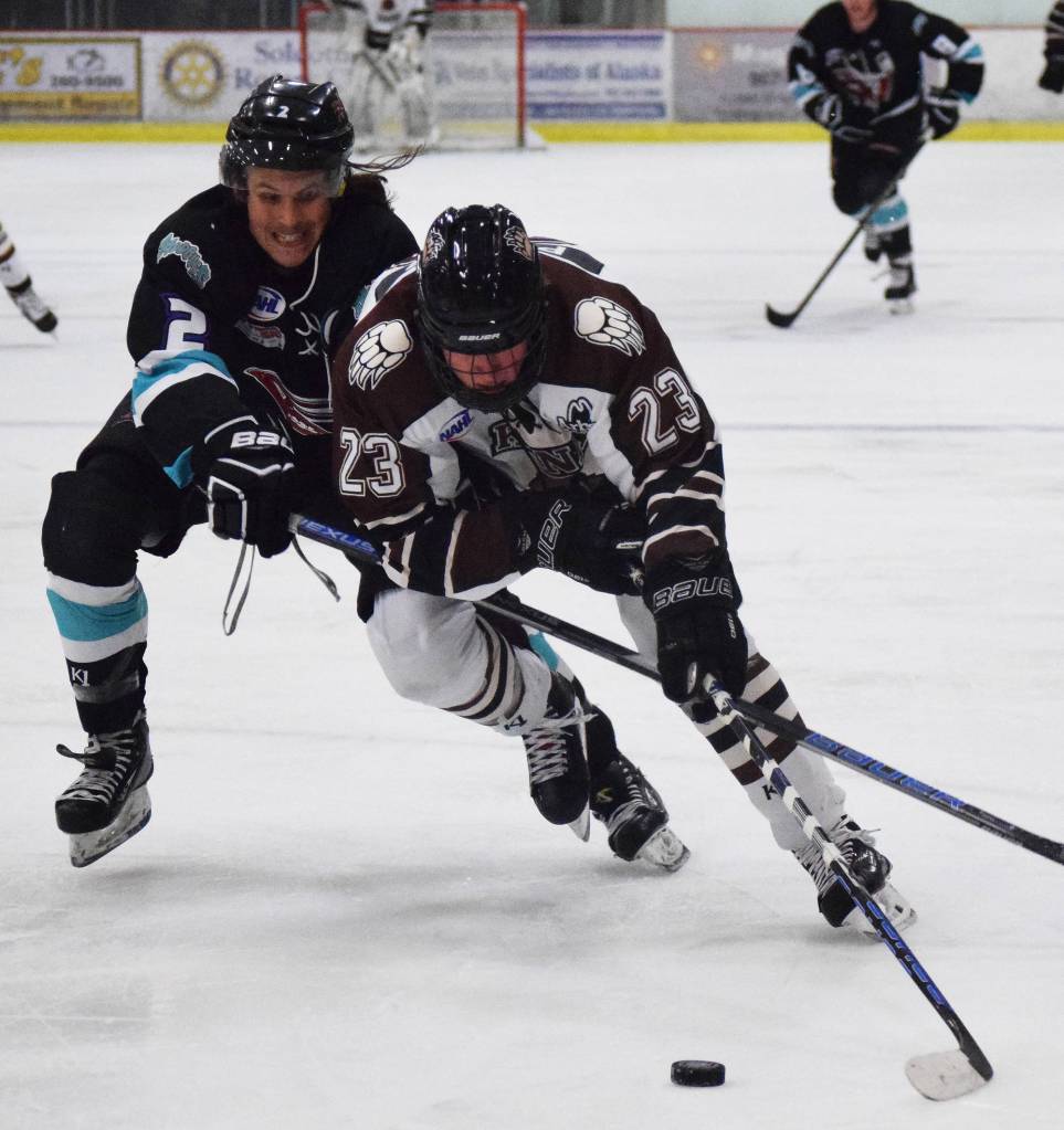 Kenai River&rsquo;s Luke Posner (23) and Shreveport&rsquo;s Dominick Procopio fight for the puck Friday night at the Soldotna Regional Sports Complex. (Photo by Joey Klecka/Peninsula Clarion)