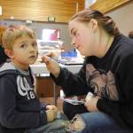 TOP: Delaney Duck, an eighth-grader at Kenai Middle School, paints Kaiden Tressler&rsquo;s face during the Mountain View Elementary School&rsquo;s carnival on Thursday, Oct. 19 in Kenai. All proceeds from the carnival go towards student activities, like field trips, according to Principal Karl Kircher.  RIGHT: Parker Wolverton participates in the cake walk during the Mountain View Elementary School carnival on Thursday, Oct. 19 in Kenai. (Photo by Kat Sorensen/Peninsula Clarion)