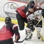 Kenai River Brown Bears forward Gil Garcia works out of the corner against Minnesota Magicians defensemen Caydon Meyer (8) and Charlie Weiand (55) on Thursday, Oct. 26, 2017, at the Soldotna Regional Sports Complex. (Photo by Jeff Helminiak/Peninsula Clarion)
