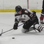 Kenai River Brown Bears forward Sutton McDonald eyes the puck in front of a Minnesota player Friday night at the Soldotna Regional Sports Complex. (Photo by Joey Klecka/Peninsula Clarion)