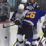 Monroe Catholic&rsquo;s Jacob Rauenhorst (26) checks Soldotna&rsquo;s J.D. Schmelzenbach into the boards Thursday at the Peninsula Ice Challenge at the Soldotna Regional Sports Complex. (Photo by Joey Klecka/Peninsula Clarion)
