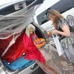 A witch in a trunk hands out candy at Trunk or Treat in Kenai.