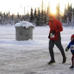Adam Reimer and his son Gus Reimer, 4, finish the 1-mile Turkey Trot race at the Soldotna Regional Sports Complex on Thursday in Soldotna. The organizers of the event, which also included a 5K race, donated all the proceeds to Freedom House, a Soldotna nonprofit sober living home for women recovering from addiction. (Photo by Elizabeth Earl/Peninsula Clarion)