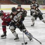 Kenai River Brown Bears forward Gil Garcia drives the net on Fairbanks Ice Dogs defenseman Jake Willets on Friday, Nov. 24, 2017, at the Soldotna Regional Sports Complex. (Photo by Jeff Helminiak/Peninsula Clarion)