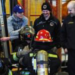 Two Kenai River Brown Bears players, blinded by blackout firefighting training masks, feel in the dark for each other during a tour and training demonstration at the Kenai Emergency Operations Center on the Kenai Municipal Airport on Tuesday, Nov. 28, 2017 in Kenai, Alaska. Kenai Fire Department firefighters walked the Brown Bears players through some of the training and tools firefighters use to give them an idea of what a career in fire response is like. (Photo by Elizabeth Earl/Peninsula Clarion)