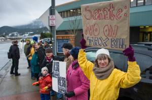 Luann McVey, right, joins about a dozen people to protest the U.S. Senate&rsquo;s proposed tax reform bill in front of Juneau&rsquo;s Congressional Delegation Office on Glacier Avenue on Wednesday, Nov. 29, 2017. (Michael Penn | Juneau Empire)