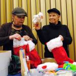 Jerri Scott, left, and Bobbi Steejes stuff stockings with holiday gifts on Thursday, Nov. 30 at the LDS Church in Soldotna, AK. The stockings will be donated to Love In the Name of Christ of the Kenai Peninsula, an inter-denominational Christian organization, which is hosting a Christmas event for families in need on Dec. 23. (Photo by Kat Sorensen/Peninsula Clarion)