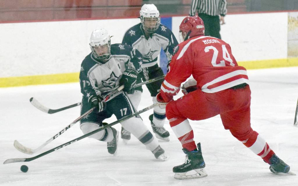 Soldotna&rsquo;s Wyatt Medcoff attacks Wasilla&rsquo;s Wyatt Moore while Soldotna&rsquo;s Alex Montague supports the puck Friday, Dec. 1, 2017, at the Soldotna Regional Sports Complex. (Photo by Jeff Helminiak/Peninsula Clarion)