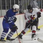 Kenai Central skater Jacob Keels scrambles to find the puck in front of Palmer&rsquo;s Noah Keil, Friday at the Kenai Multipurpose Facility. (Photo by Joey Klecka/Peninsula Clarion)