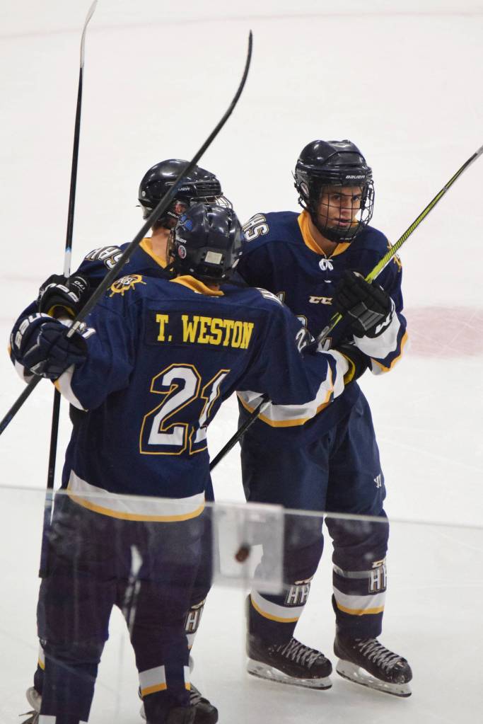 Homer&rsquo;s Phin Weston (right) receives congratulations from Tucker Weston in a game against Soldotna, Tuesday night at the Soldotna Regional Sports Complex. (Photo by Joey Klecka/Peninsula Clarion)