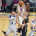 Cook Inlet Academy&rsquo;s Hunter Moos battles Nikolaevsk&rsquo;s Randy Boquecosa and Isaak Fefelov for a loose ball Friday, Dec. 15, 2017, at Cook Inlet Academy. (Photo by Jeff Helminiak/Peninsula Clarion)