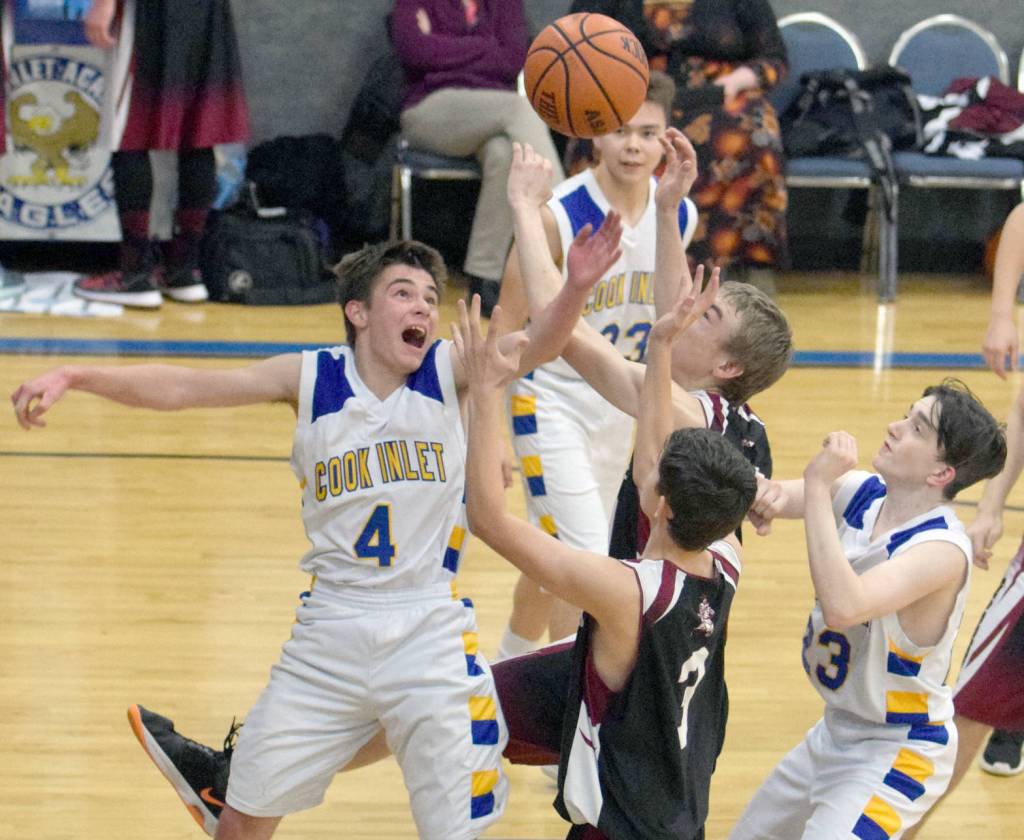 Cook Inlet Academy&rsquo;s Hunter Moos battles Nikolaevsk&rsquo;s Randy Boquecosa and Isaak Fefelov for a loose ball Friday, Dec. 15, 2017, at Cook Inlet Academy. (Photo by Jeff Helminiak/Peninsula Clarion)