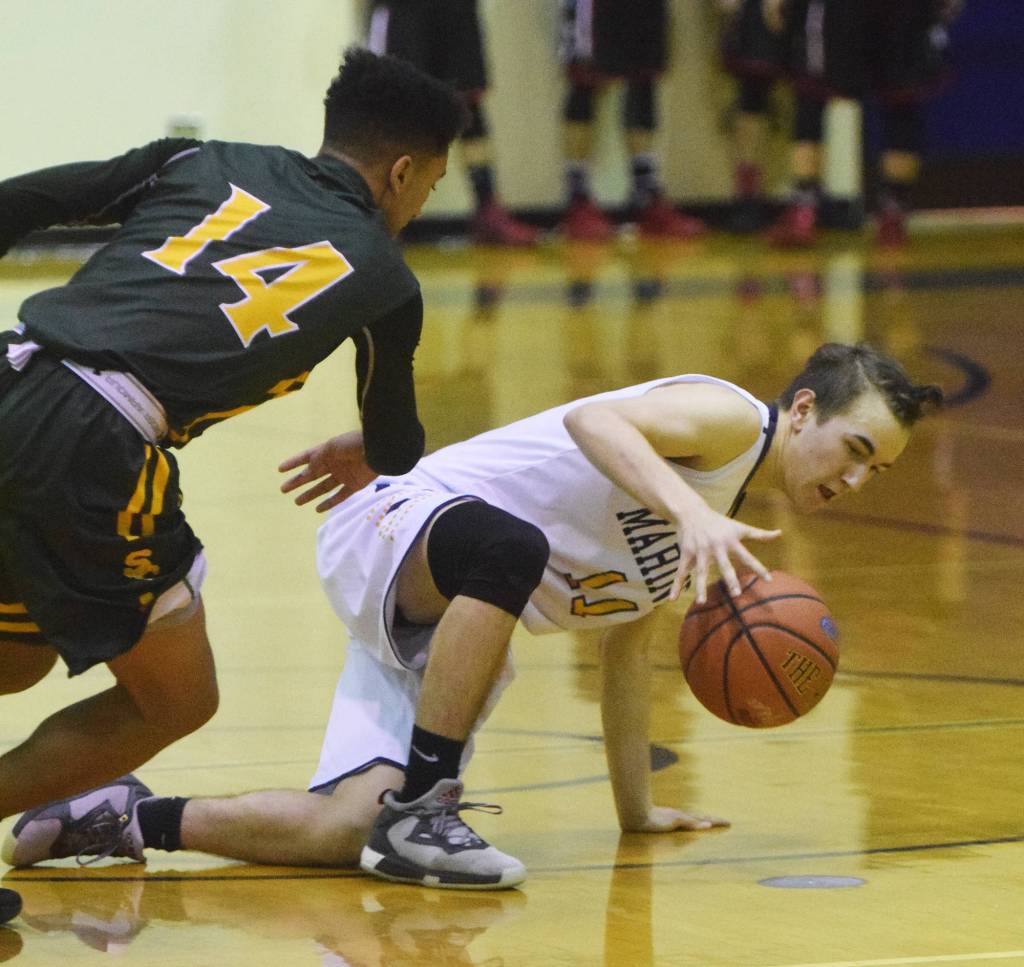 Homer&rsquo;s Daniel Reutov slips while dribbling the ball with pressure from Service&rsquo;s Brandon Gail (14) Friday at the Powerade/Al Howard Tip-Off tournament at Soldotna High School. (Photo by Joey Klecka/Peninsula Clarion)