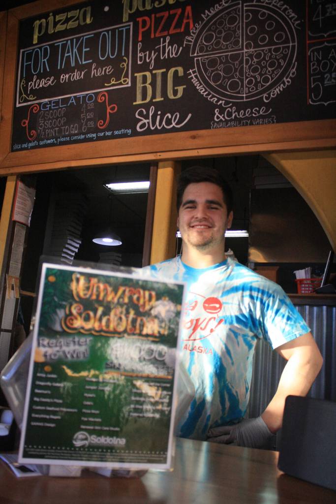 Pizza Boys manager Robbie Smithwick poses with an entry form container on Dec. 18. Pizza Boys is one of 19 Soldotna businesses participating in the &ldquo;Unwrap Soldotna&rdquo; campaign.